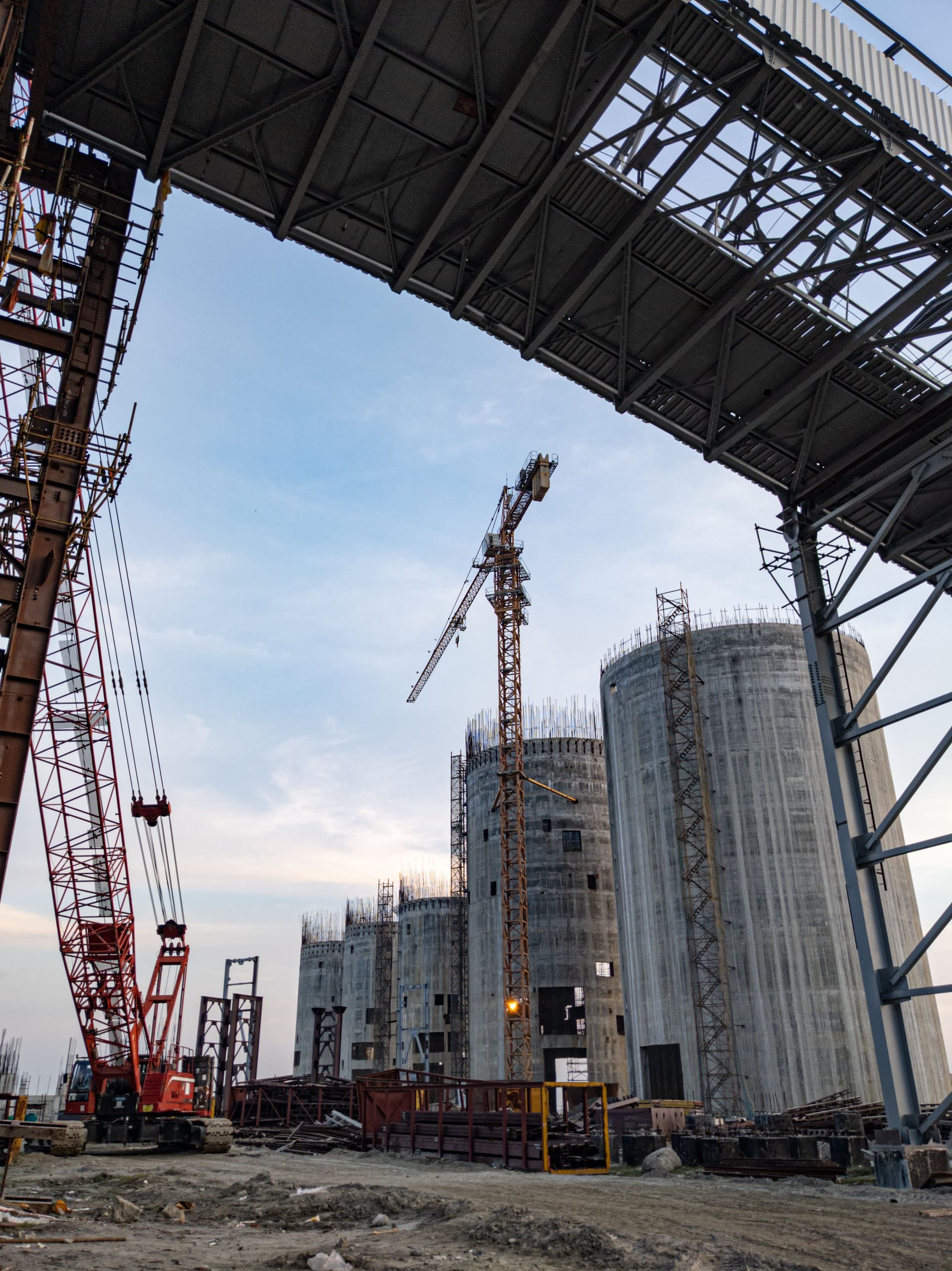 Industrial construction site with crane and concrete structures at dusk